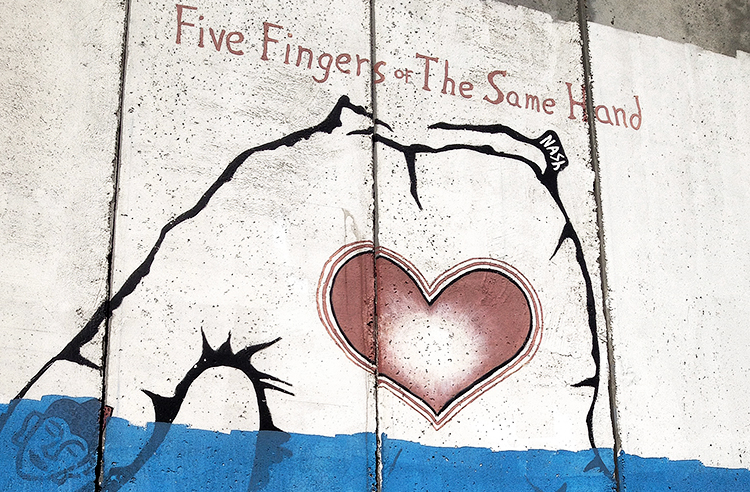 Grens Westbank, muurschildering Israel - five fingers of the same hand